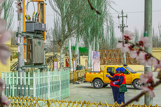 国网和田供电公司党员服务队来到罕艾日克镇稻香村开展安全用电检查。甄立民 摄