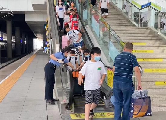 鐵路客運員楊順攙扶帶有行李與小孩的乘客。李子良 攝