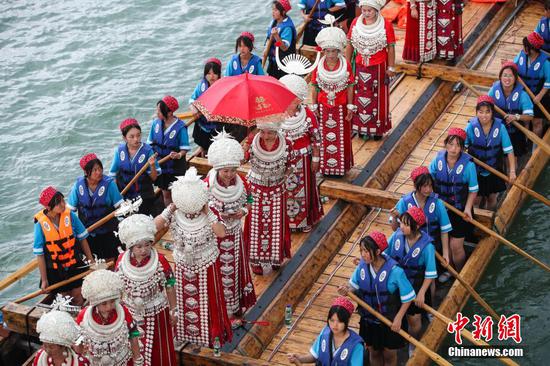 穿着少数民族盛装的人员参加木龙舟游江展演。 瞿宏伦 摄