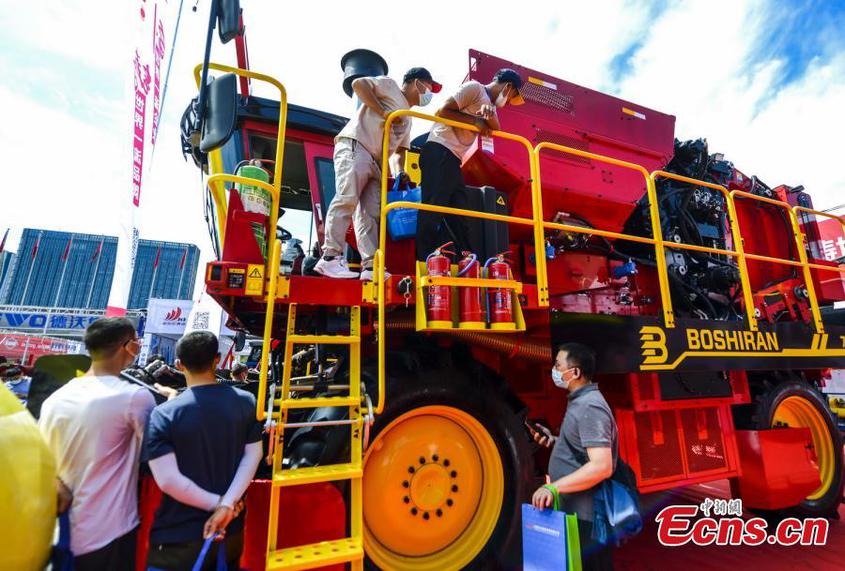 Visitors take a close look on a cotton picker during the 2022 agricultural machinery expo in Urumqi, capital of northwest China's Xinjiang Uyghur Autonomous Region, July 3, 2022. (Photo: China News Service/Liu Xin)

