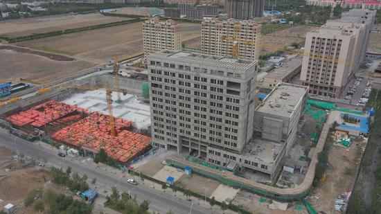 7月7日，正在建设当中的新疆医科大学第一附属医院昌吉分院中医楼建设项目。冯国峰 摄
