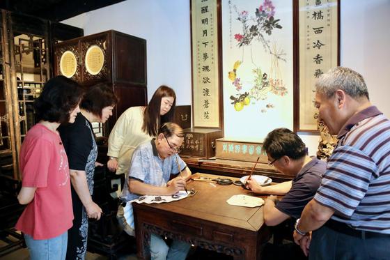 张长勇、朱兆煜在天津百年劝业博物馆画扇子，送清凉