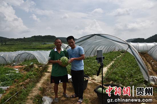 瓜农杨洪泽（左）和客商（右）正在西瓜基地直播卖瓜。刘坤 摄