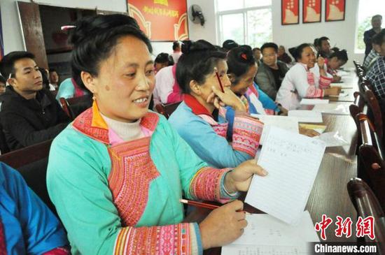 资料图：榕江县定威乡少数民族群众在培训班上学写汉字。　贵州省民宗委供图