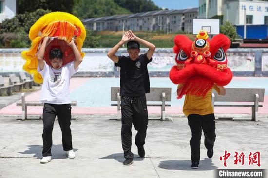 赖翊凡(中)带着成员万杰(左)和万金宇练习舞狮头。　瞿宏伦 摄