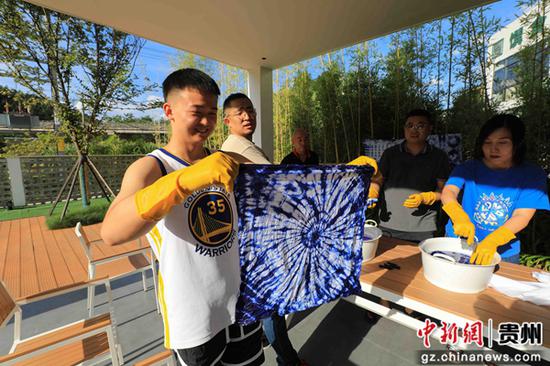 7月14日，游客在贵州省铜仁市江口县太平镇梵净山村三山里民宿体验传统扎染工艺。
