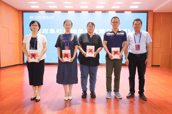 天津外国语大学党委书记殷奇为“一基地三库”负责人赠书。天津外国语大学供图。