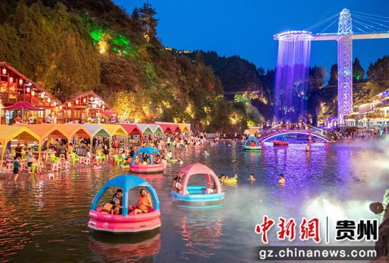 2022年7月16日，贵州省黔东南苗族侗族自治州施秉县杉木河夜漂景区灯火辉煌，流光溢彩，游客们在游玩度假，娱乐打卡。磨桂宾 摄