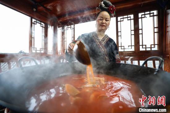 图为6月9日，贵州雷山，李珍在制作酸汤鱼。 中新社记者 瞿宏伦 摄