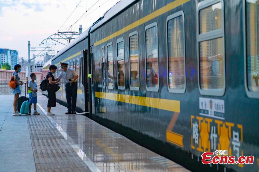 Passengers go aboard the train in Urumqi， northwest China‘s Xinjiang Uyghur Autonomous Region， July 25， 2022。 （Photo： China News Service/Zhang Shan）

