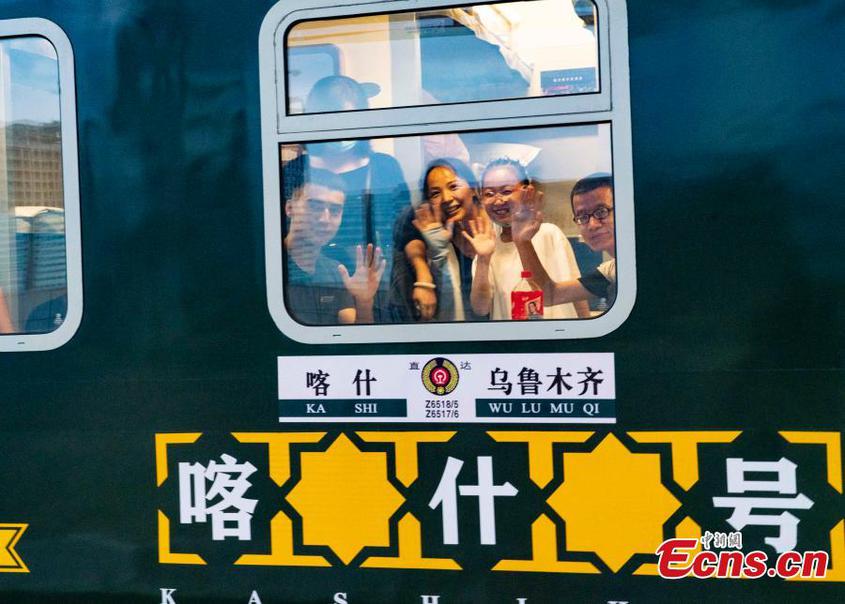 　　Passengers wave to leave Urumqi on the first direct sleeper train in northwest China‘s Xinjiang Uyghur Autonomous Region， July 25， 2022。 （Photo： China News Service/Zhang Shan）