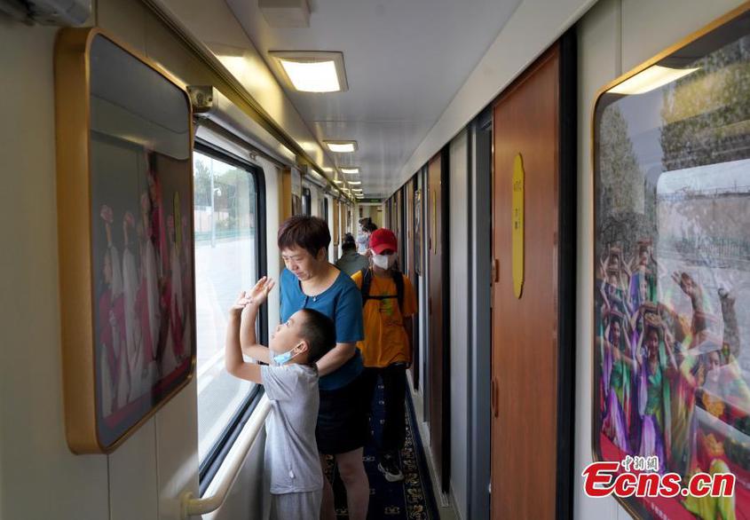 Passengers enjoy the view on the non-stop tourism train in northwest China‘s Xinjiang Uyghur Autonomous Region， July 25， 2022。 （Photo： China News Service/Zhang Shan）