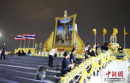 7月27日，泰国曼谷王家田广场，工作人员连夜在泰国十世王玛哈·哇集拉隆功大幅画像前布置鲜花。7月28日是哇集拉隆功国王的70岁生日，泰国全国放假一天庆祝。中新社记者 王国安 摄