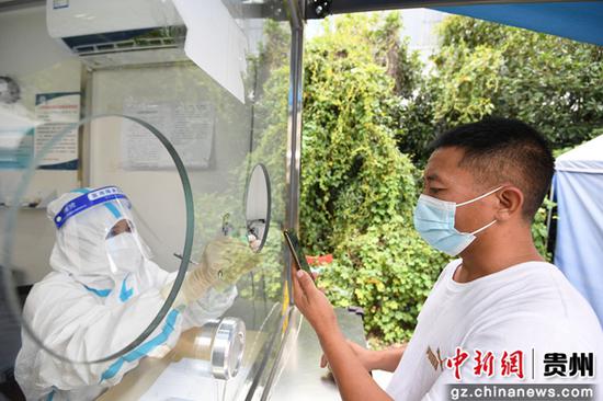 8月7日，医护人员正在贵阳市南明区牛郎关高速路口防疫服务点免费为入黔返黔的大型货车司机进行核酸采样。