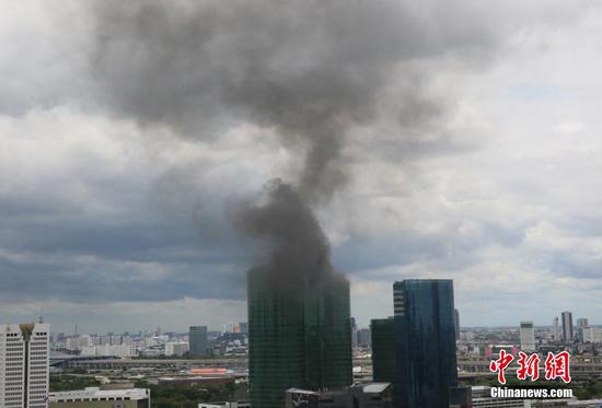当地时间8月7日，位于泰国曼谷的泰国能源部办公大楼发生火灾，楼顶冒出滚滚浓烟。据悉，起火楼层位于大楼33层，目前火势已被控制住，暂无人员伤亡。具体起火原因正在调查中。 中新社记者 王国安 摄