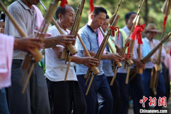 芦笙手在丹寨县扬武镇排倒村芦笙场上吹奏传统芦笙乐曲。　黄晓海 摄