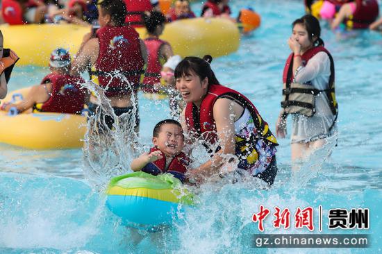 8月14日，游客在贵州石阡古温泉水上乐园“冲浪池”戏水。 瞿宏伦 摄