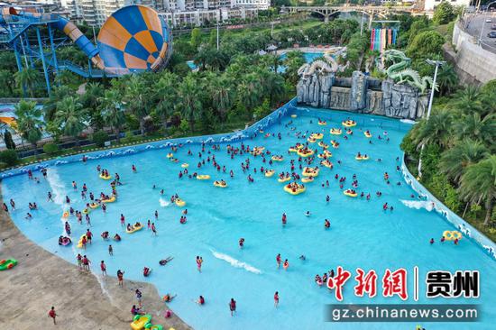 8月14日，航拍游客在贵州石阡古温泉水上乐园“冲浪池”戏水。 瞿宏伦 摄