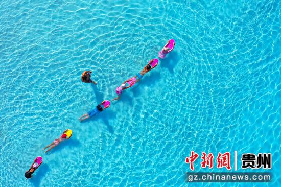 8月14日，航拍游客在贵州石阡古温泉水上乐园练习游泳。 瞿宏伦 摄