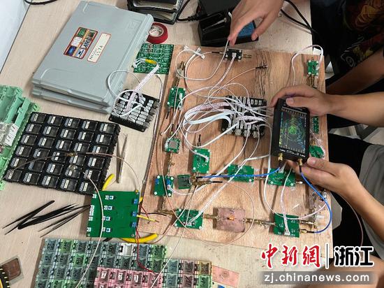 团队学生拿着设备测试电路。 杭州电子科技大学 供图