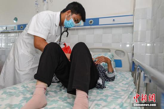 8月17日，李田书在琊川镇中心卫生院病房为患者做检查。 瞿宏伦 摄