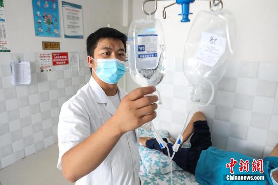 8月17日，李田书在琊川镇中心卫生院病房查看患者输液情况。 瞿宏伦 摄