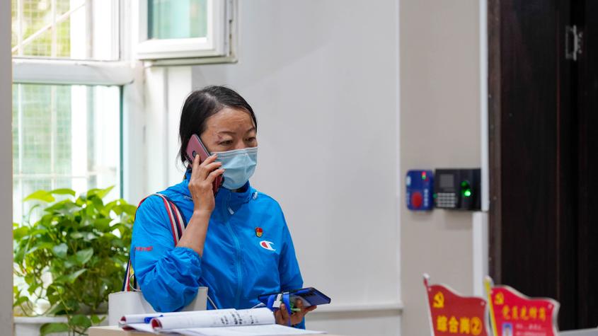 8月17日，在尉犁县尉犁镇金宇社区，社区党支部书记蔡伟芳正在与居家隔离医学人员进行电话沟通。王雪 摄