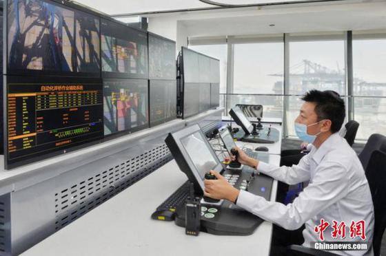 资料图为天津港工作人员操控自动化岸桥作业辅助系统。 中新社记者 佟郁 摄