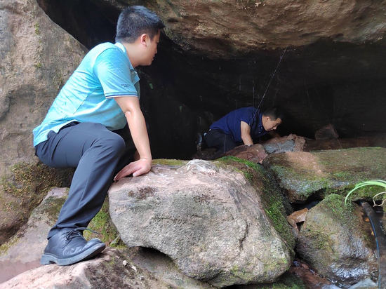 图为李兆文带领村干部在洞中寻水源