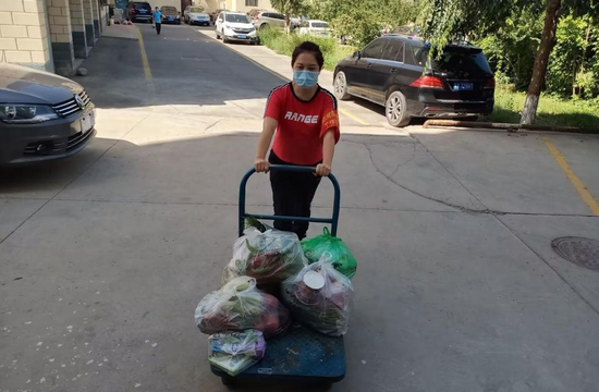 图为额敏县农信社志愿者向居民运送生活物资。李红军 摄