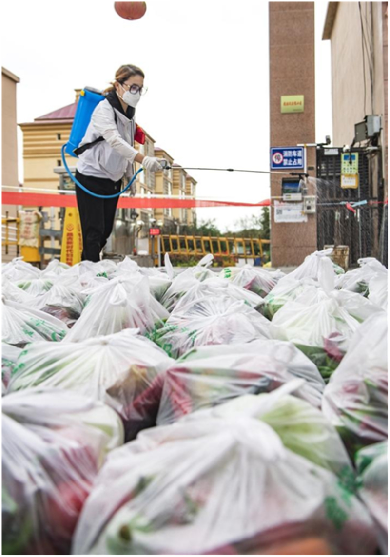 　　8月20日，呼图壁县熙景晓月小区，志愿者对为居民配送的蔬菜外包装进行消杀。


