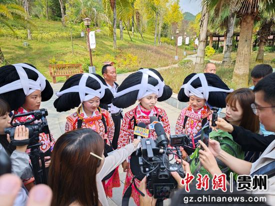 8月25日上午，参访媒体采访长角苗原生态歌舞表演者    唐哲 摄