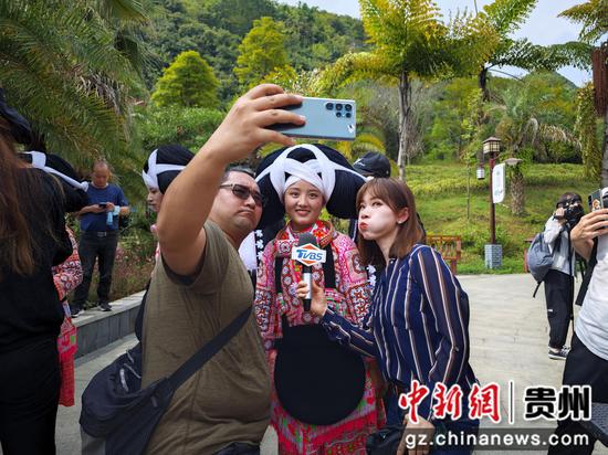 台湾媒体记者和长角苗姑娘合影。唐哲  摄