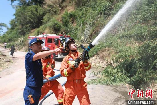 图为贵州消防指战员利用水枪压制山火。　贵州省消防救援总队供图
