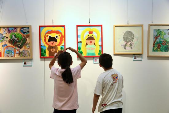 参展小艺术家在展览现场交流。