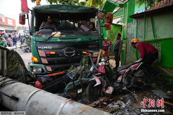 据美联社报道当地时间2022年8月31日，印尼西爪哇省勿加泗发生一起严重交通事故，一辆运铁的卡车在一所学校前的公共汽车站撞毁，事故造成至少10人死亡，现场约有20名伤者被紧急送往医院。图为警察正在清理事故现场的车辆碎片。