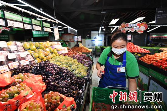 9月3日，贵阳市南明区惠民生鲜合力超市南浦路店的工作人员正在贵州绿色优质农产品销售专区摆放果蔬。
