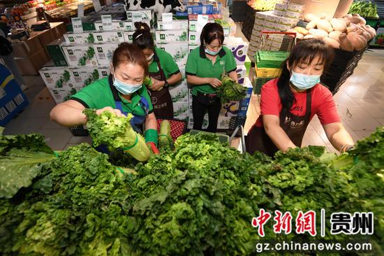 9月3日，贵阳市南明区惠民生鲜合力超市南浦路店的工作人员正在贵州绿色优质农产品销售专区摆放果蔬。
