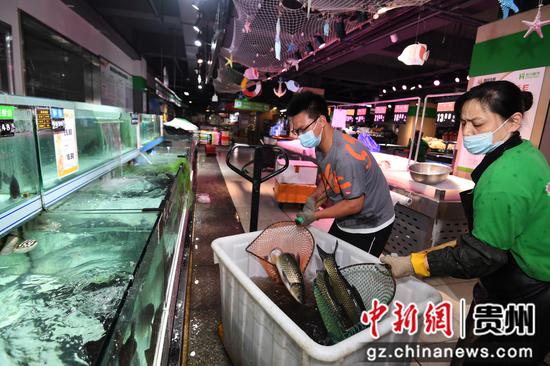 9月3日，贵阳市南明区惠民生鲜合力超市南浦路店的工作人员正在为水产区加货补货。