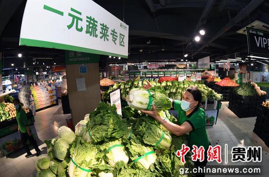 9月3日，贵阳市南明区惠民生鲜合力超市南浦路店的工作人员正在一元蔬菜专区摆放蔬菜。