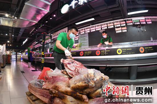 9月3日，贵阳市南明区惠民生鲜合力超市南浦路店的工作人员正在生肉区摆放猪肉，准备分割。