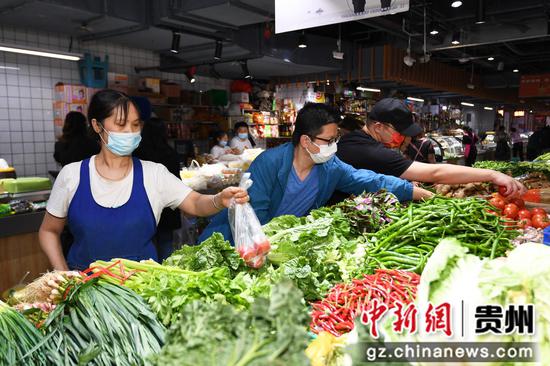 9月3日，市民正在贵阳市南明区新路口农贸市场选购蔬菜。