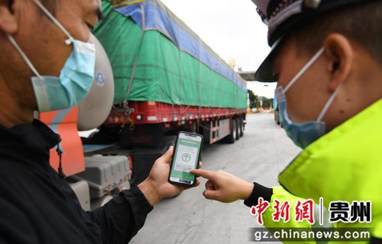 9月4日上午，交警在牛郎关高速公路防疫卡点查验入黔返黔民生物资运输和货运司机的通行证及“双码”。