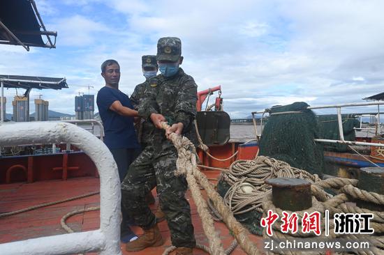 执法人员帮助船民加固缆绳。 浙江海警局 供图