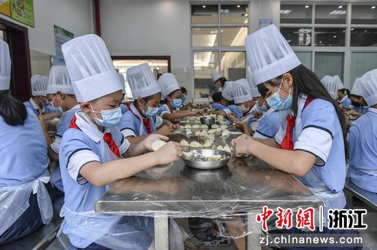 小学生在老师指导下学习包饺子。 陈月明（通讯员） 摄