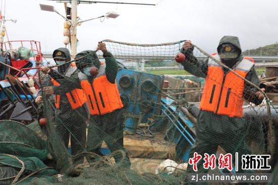 执法人员帮助船民收纳渔具。 浙江海警局 供图