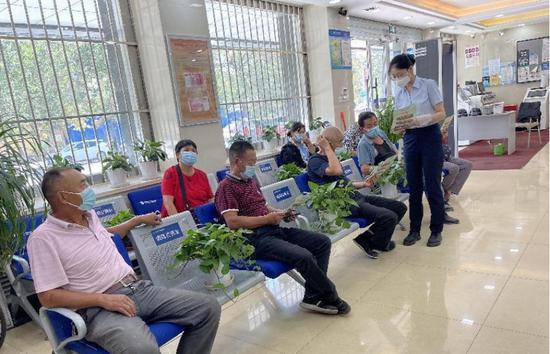 图为9月7日，乌鲁木齐农商银行安宁渠支行的工作人员为等候办理业务的客户提供咨询服务。 李春欣 摄