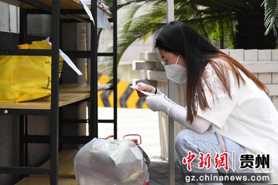 9月8日，在贵阳市南明辖区一小区物资接驳点，居民在自取配送的生活物资。