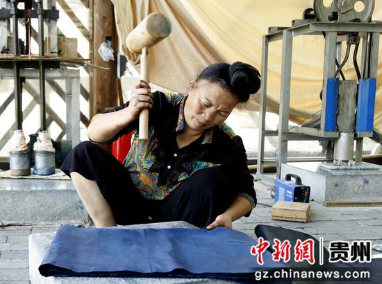 2022年9月8日，贵州省施秉县舞水云台旅游商品开发有限公司一位苗族技师在捶布“上光”。