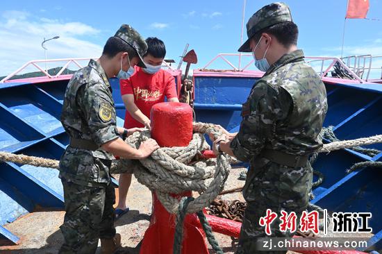 执法员帮助船民进行安全检修。浙江海警局供图